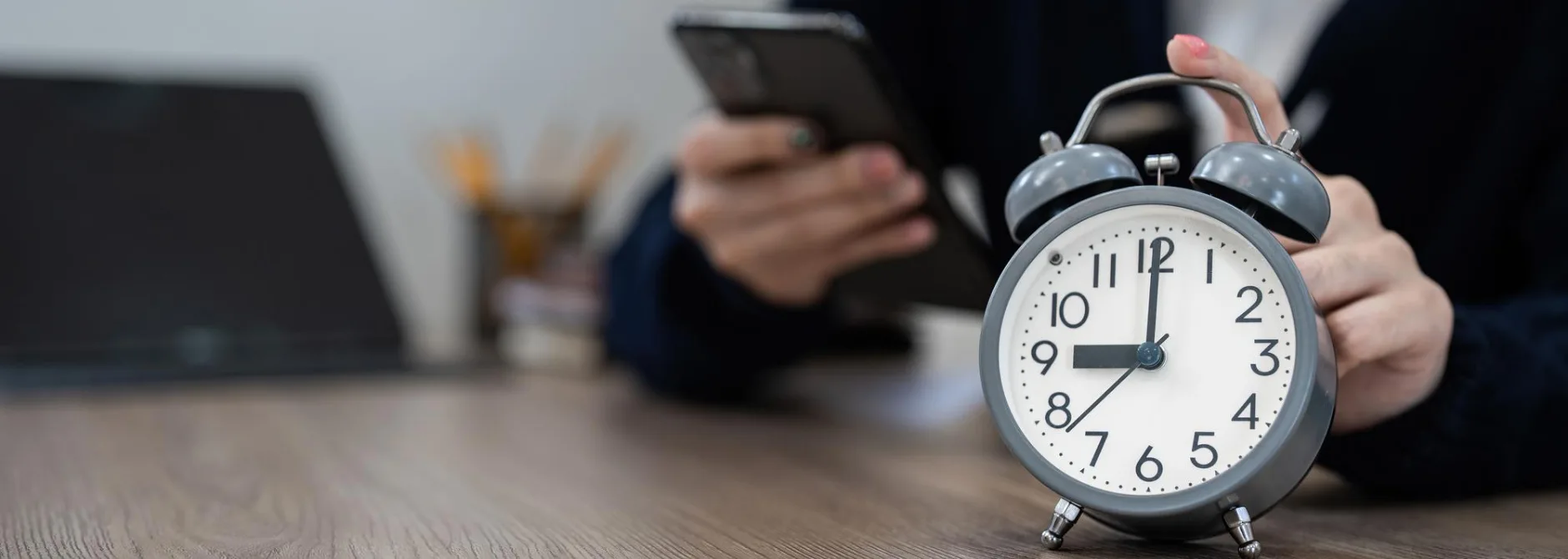 alarm clock wooden table with business working home time concept early morning overtime evening