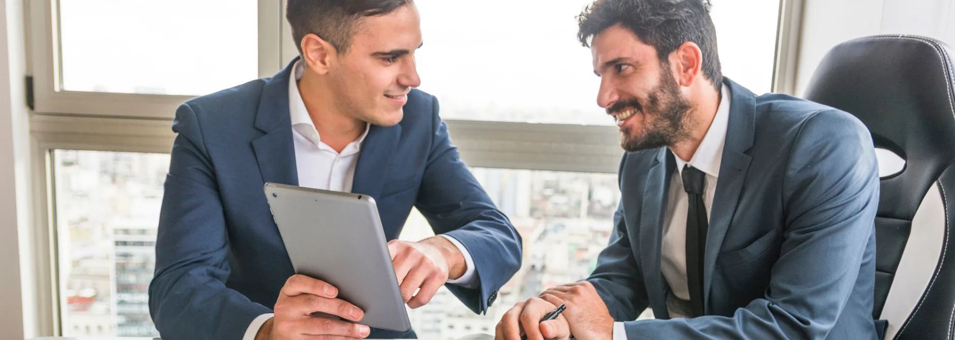male employee showing his partner digital tablet meeting
